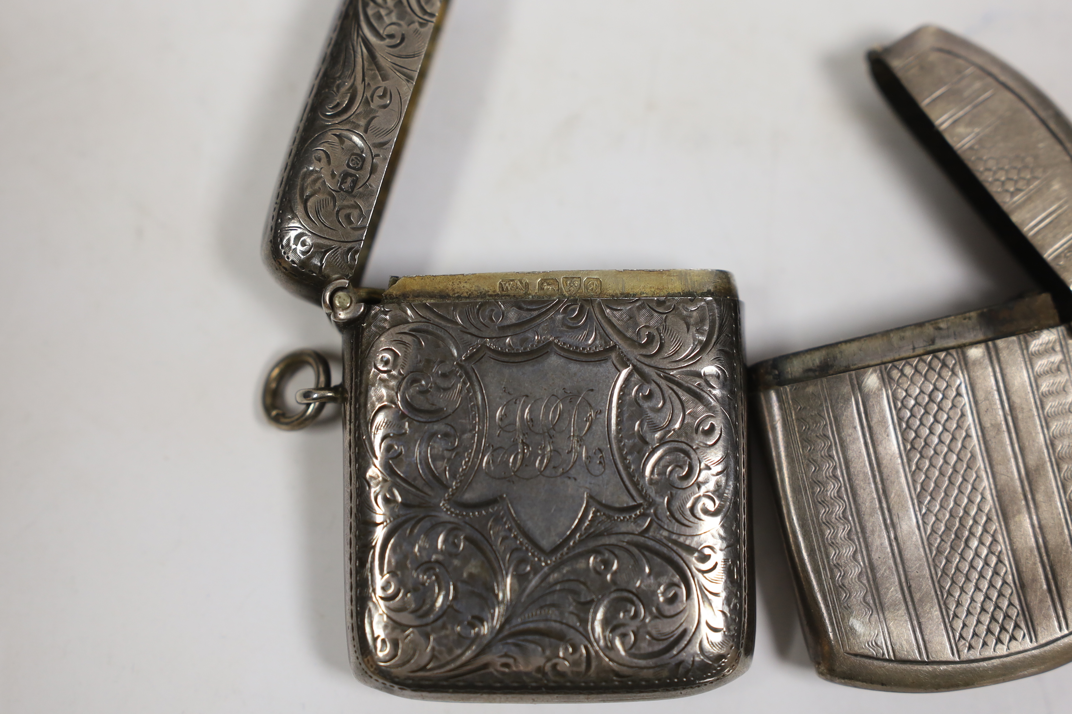 Three various silver vesta cases, together with a silver albert.